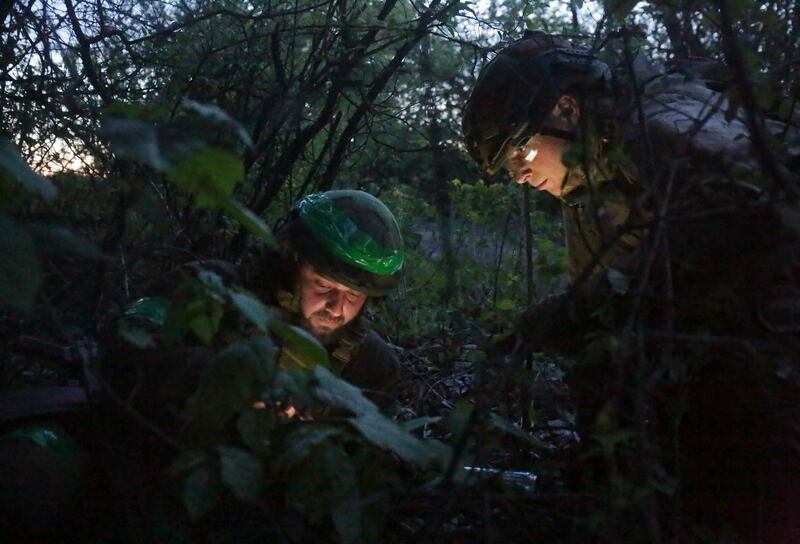 Ukrainian servicemen study a map near Kharkiv. EPA