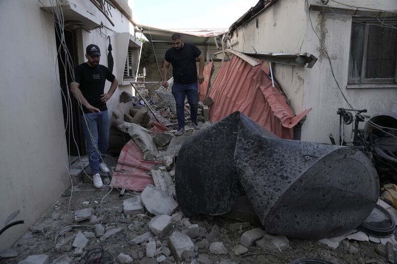 Palestinians survey the ruins of the home of Mr Kharousha, who had been accused of shooting two Israelis dead. AP