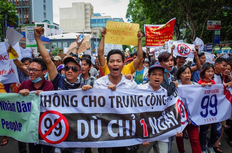 Vietnamese protesters shout slogans against a proposal to grant companies lengthy land leases during a demonstration in Ho Chi Minh City on June 10, 2018. The draft law at the centre of the furore would allow 99-year concessions in planned special economic zones, which some view as sweetheart deals for foreign and specifically Chinese firms. / AFP / Kao NGUYEN
