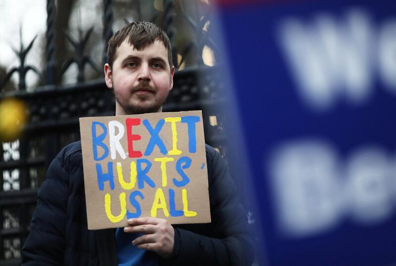 An anti-Brexit protester holding a banner demonstrates outside the Houses of Parliament in London. Reuters