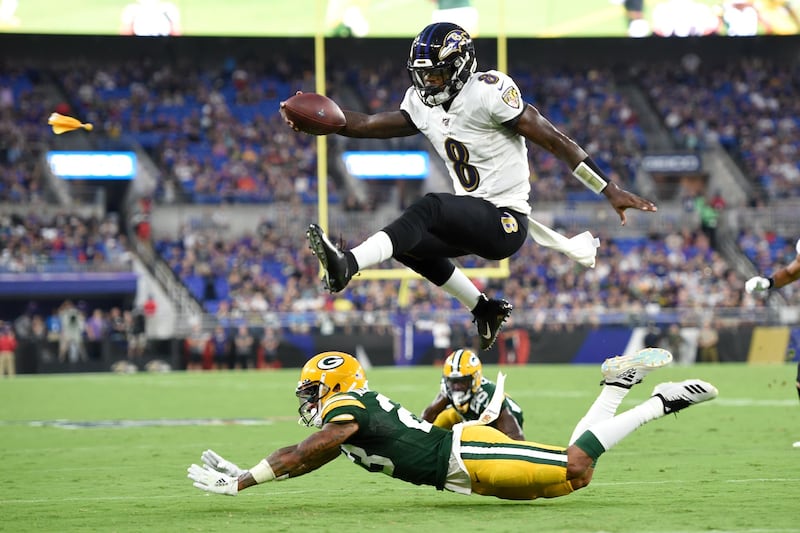 Baltimore Ravens quarterback Lamar Jackson leaps over Green Bay Packers cornerback Jaire Alexander in Baltimore. AP Photo