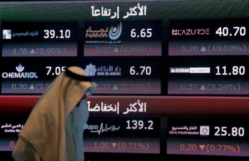 FILE PHOTO: An investor walks past a screen displaying stock information at the Saudi Stock Exchange (Tadawul) in Riyadh, Saudi Arabia June 29, 2016. REUTERS/Faisal Al Nasser/File Photo