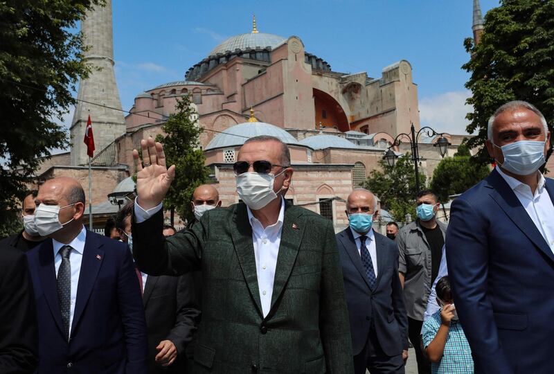 This handout picture released by the Turkish Presidential press office shows Turkish President Tayyip Erdogan (C), flanked by flanked by Turkish Culture and Tourism Minister Mehmet Nuri Ersoy (R), greeting people as he leaves the Hagia Sophia monument in Istanbul, on July 19, 2020.   Turkey's Hagia Sophia will open to visitors outside prayer times and its Christian icons will remain, religious officials said on July 14, 2020 after a court ruling paved the way for it to become a mosque. Hagia Sophia was a cathedral for nearly 1,000 years before being converted into a mosque in 1453 and a museum in 1935. - RESTRICTED TO EDITORIAL USE - MANDATORY CREDIT "AFP PHOTO / HO / TURKISH PRESIDENTIAL PRESS OFFICE" - NO MARKETING - NO ADVERTISING CAMPAIGNS - DISTRIBUTED AS A SERVICE TO CLIENTS
 / AFP / TURKISH PRESIDENTIAL PRESS SERVICE / Handout / RESTRICTED TO EDITORIAL USE - MANDATORY CREDIT "AFP PHOTO / HO / TURKISH PRESIDENTIAL PRESS OFFICE" - NO MARKETING - NO ADVERTISING CAMPAIGNS - DISTRIBUTED AS A SERVICE TO CLIENTS
