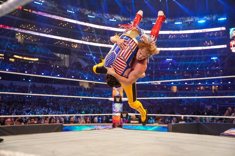 Logan Paul suplexes Dominik Mysterio during a tag team match at WrestleMania 38.
