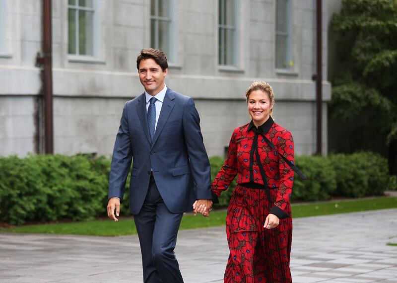 (FILES) In this file photo taken on September 11, 2019 Canada's Prime Minister Justin Trudeau and his wife Sophie Gregorie Trudeau arrives at Rideau Hall in Ottawa. Canadian Prime Minister Justin Trudeau and his wife announced they were self-isolating on March 12, 2020 as she undergoes tests for the new coronavirus after returning from a speaking engagement with "mild flu-like symptoms." Sophie Gregoire-Trudeau's symptoms have subsided since she recently got back from Britain, but as a precaution the prime minister "will spend the day in briefings, phone calls and virtual meetings from home," according to a statement. / AFP / Dave Chan
