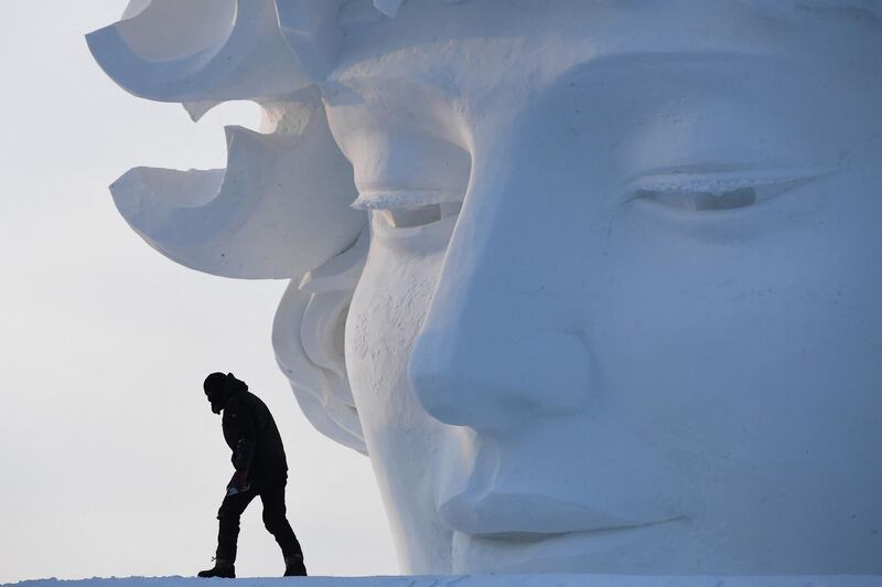 A worker walks past a snow sculpture at the Harbin Ice and Snow Sculpture Festival.  Greg Baker / AFP Photo