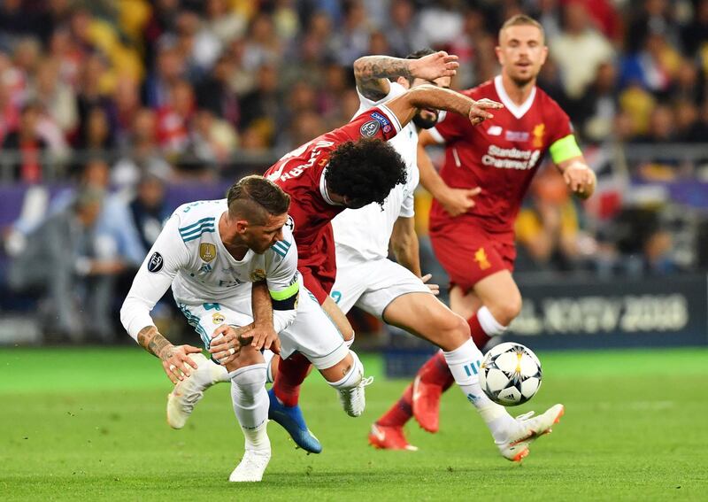 epa06765936 Real Madrid's Sergio Ramos (L) and Mohamed Salah (C) of Liverpool FC in action during the UEFA Champions League final between Real Madrid and Liverpool FC at the NSC Olimpiyskiy stadium in Kiev, Ukraine, 26 May 2018.  EPA/GEORGI LICOVSKI