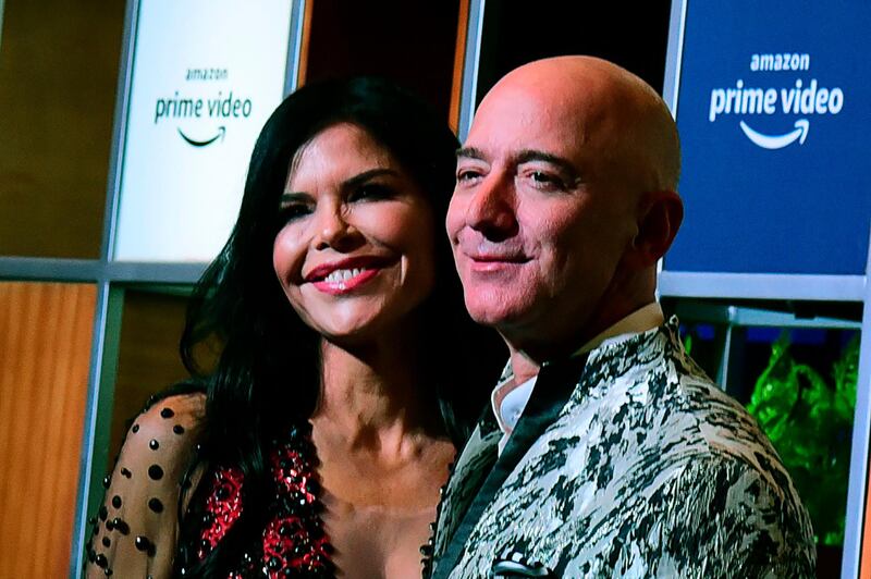 CEO of Amazon Jeff Bezos (R) and his girlfriend Lauren Sanchez (L) pose for pictures as they arrive to attend an event in Mumbai on January 16, 2020.  / AFP / Sujit Jaiswal
