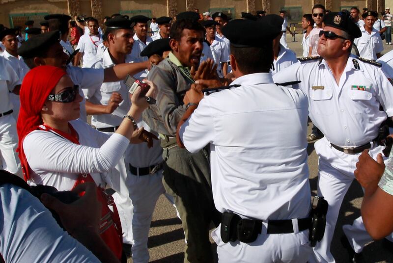 A protester against Egypt's former President Hosni Mubarak is stopped by police officers during clashes with pro-Mubarak supporters outside the police academy where his trial will take place, in Cairo August 3, 2011. Mubarak was shown wheeled into a cage in court in Cairo on Wednesday with his two sons and other defendants to stand trial for his role in the killing of protesters, state television images showed. REUTERS/Amr Abdallah Dalsh  (EGYPT - Tags: CIVIL UNREST POLITICS CRIME LAW) *** Local Caption ***  AMR26_EGYPT-MUBARAK_0803_11.JPG