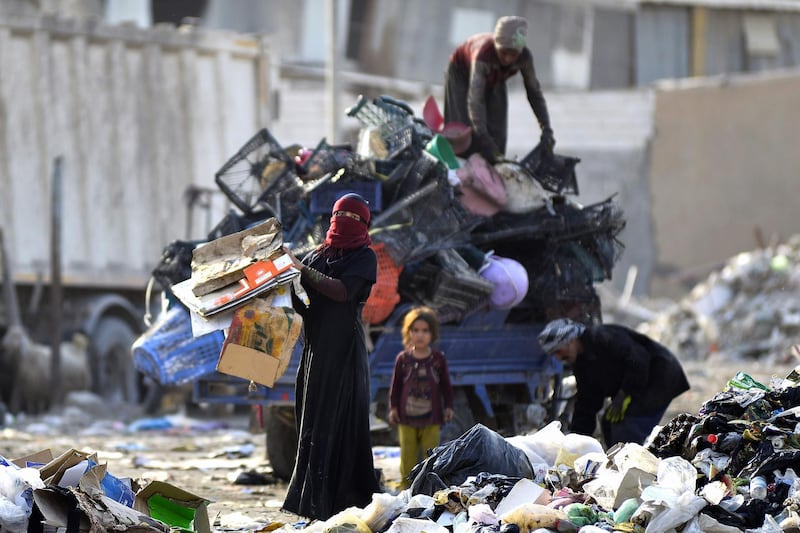 People collect recyclable items at a landfill to be sold for extra income, in the Iraqi city of Najaf.  AFP