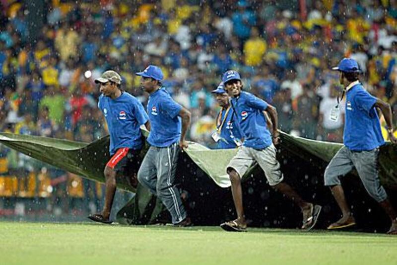The ground staff bring in the covers at the R Premadasa Stadium in Colombo.