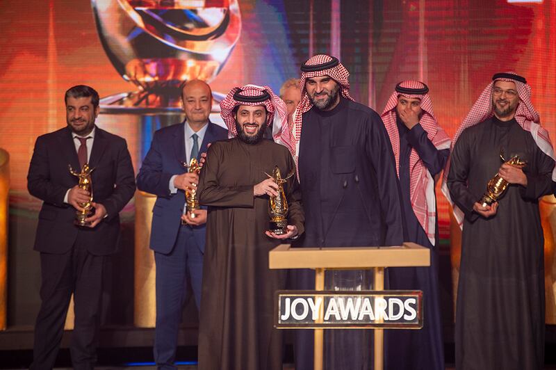  Turki Al Sheikh (centre left), chairman of the Board of Directors of General Entertainment Authority, holds a Joy Award during the ceremony.