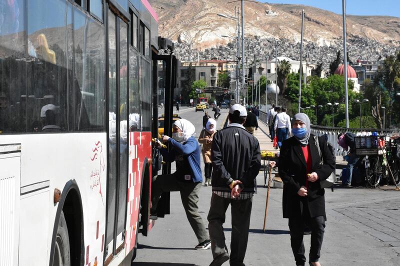 People board a bus at a station in Damascus, Syria on the first day of the government's decision to allow public and private transport to resume after an almost two-month stoppage.  EPA