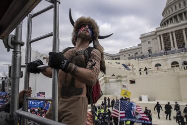 A protester climbs scaffolding as demonstrators swarm the U.S. Capitol building in Washington, DC on Wednesday. Victor J. Blue/Bloomberg