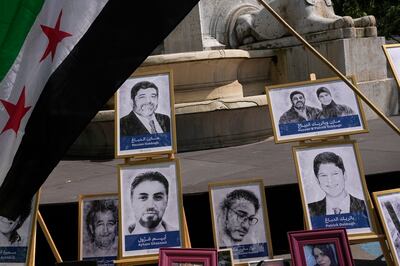 Portraits of Mazen and Patrick Dabbagh at a protest against the Syrian regime in Paris. AP 