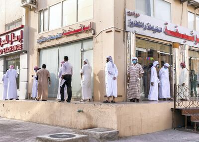 ABU DHABI, UNITED ARAB EMIRATES. 2- MAY 2020.
Men line up at the money exchange in Baniyas neighborhood, as they prepare for Eid Al Fitr.
(Photo: Reem Mohammed/The National)

Reporter:
Section: