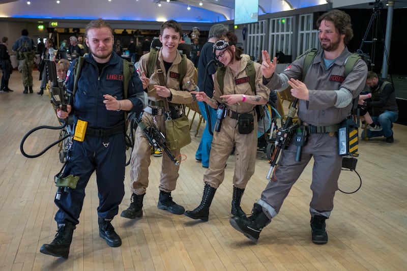 A group of friends dressed as characters from the movie Ghostbusters dance along to music on day one