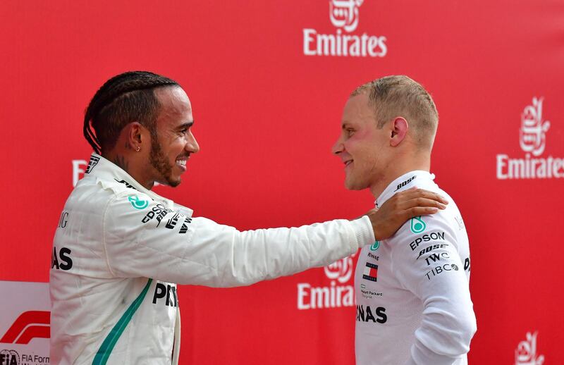 TOPSHOT - Winner Mercedes' British driver Lewis Hamilton (L) talks with second placed Mercedes' Finnish driver Valtteri Bottas after the German Formula One Grand Prix at the Hockenheim racing circuit on July 22, 2018 in Hockenheim, southern Germany.  / AFP / Andrej ISAKOVIC
