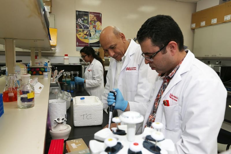 Dr Omar El Agnaf, centre, in his lab at the College of Medicine and Health Sciences in Al Ain. He and fellow  researchers have developed antibodies to be used in the Parkinson’s fight. Pawan Singh / The National