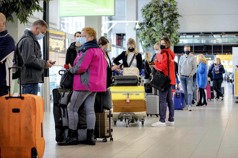 Holidaymakers queue as they leave from Schiphol airport in Amsterdam for a test holiday on April 12, 2021, amid the Covid-19 pandemic. The aim is to see whether a test protocol makes it possible to travel despite the Covid-19 pandemic. - Netherlands OUT
 / AFP / ANP / ROBIN VAN LONKHUIJSEN
