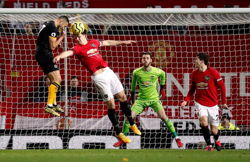 Manchester United's Harry Maguire heads the ball clear under pressure from Wolverhampton Wanderers' Romain Saiss. PA