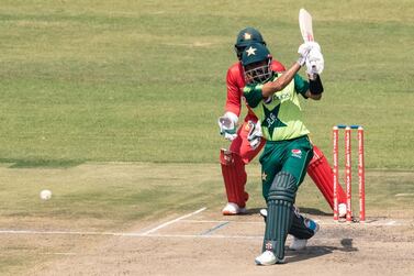 Pakistan's Babar Azam plays a shot as wicket keeper Regis Chakabva looks on during the third Twenty20 international cricket match between Zimbabwe and Pakistan at the Harare Sports Club in Harare on April 25, 2021. / AFP / Jekesai NJIKIZANA