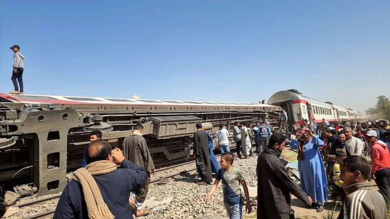 People inspect the scene of a train crash in Sohag province. EPA