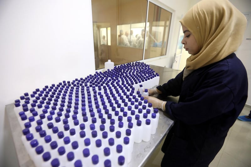 A Palestinian woman works at a factory manufacturing sanitisers, near the West Bank City of Jenin.  EPA