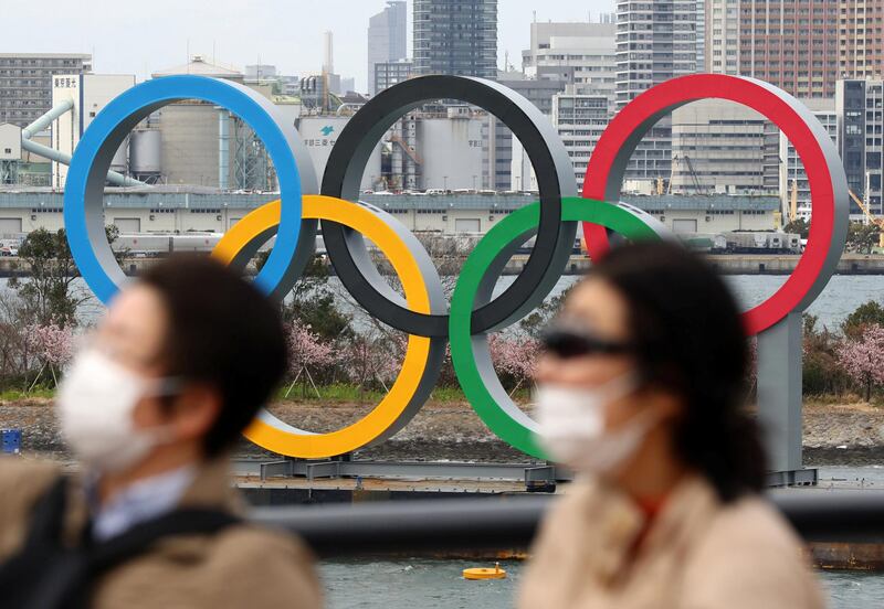 People wearing a mask walk near the Olympics' mark in Odaiba, Tokyo on February 22, 2020, amid the outbreak of a new coronavirus in Japan. ( The Yomiuri Shimbun )