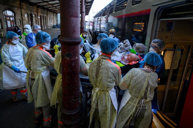 Medical staff carry a patient infected with the Covid-19 onboard a medicalized TGV high speed train at the railway station in Strasbourg. Pool via Reuters