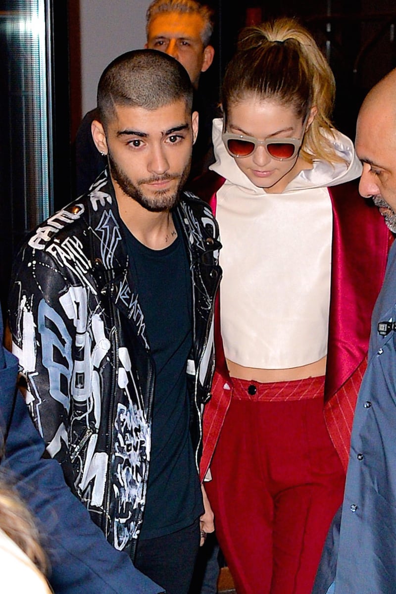 NEW YORK, NY - MARCH 25:  Zayn Malik and girlfriend supermodel Gigi Hadid help a fan that fainted after seeing the couple leaving their East Village apartment on March 25, 2016 in New York City.  (Photo by Robert Kamau/GC Images)