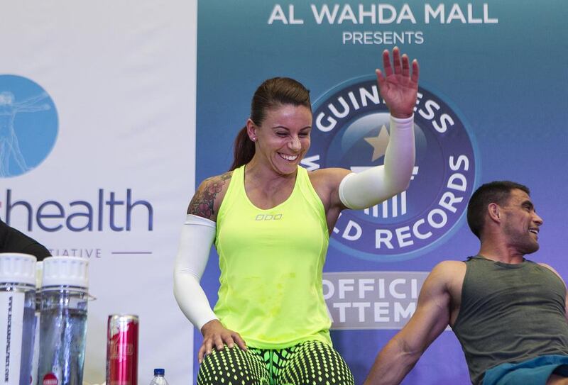 Eva Clarke waves to supporters during her gruelling world record attempt for knuckle push-ups held at Abu Dhabi's Al Wahda Mall over the weekend. Mona Al Marzooqi/ The National 

