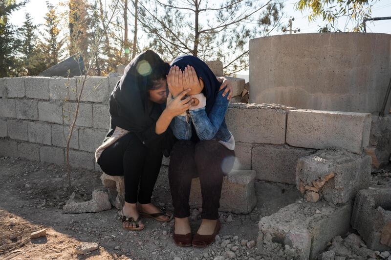 SEWAKA, IRAQ: Kazheen is comforted as she cries at the grave her father Captain Camaran Omar, a peshmerga who died fighting ISIS. Photo by  Sebastian Meyer