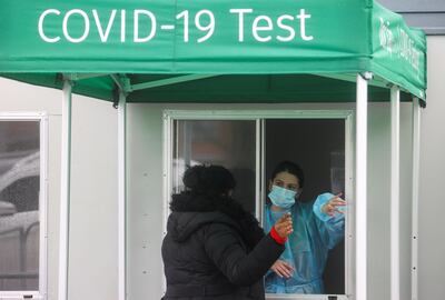 FILE PHOTO: A health care worker speaks to a woman at the coronavirus disease (COVID-19) mobile testing site at Heathrow Airport, in London, Britain, February 15, 2021. REUTERS/Hannah McKay/File Photo