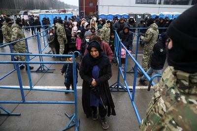 Migrants queue to receive food at a transport and logistics centre in the Grodno region. Reuters