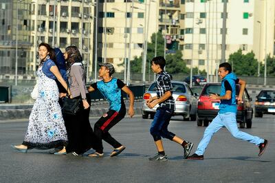 FILE - In this Aug. 20, 2012 file photo, an Egyptian youth, trailed by his friends, gropes a woman crossing the street with her friends in Cairo, Egypt. In the summer of 2020, more than a hundred allegations of sexual harassment, assault and rape against a former student at a top university have roiled Egypt, sparking a renewed #MeToo campaign in a country where sexual assault and harassment are rampant. The case has prompted the Sunni Muslim worldâ€™s foremost religious institution, to speak out on sexual harassment and assault, and voice support for victims. Authorities have arrested the accused man pending investigations, and are working to amend the country's laws to protect the identities of victims of sexual crimes. (AP Photo/Ahmed Abd El Latif, El Shorouk Newspaper, File)