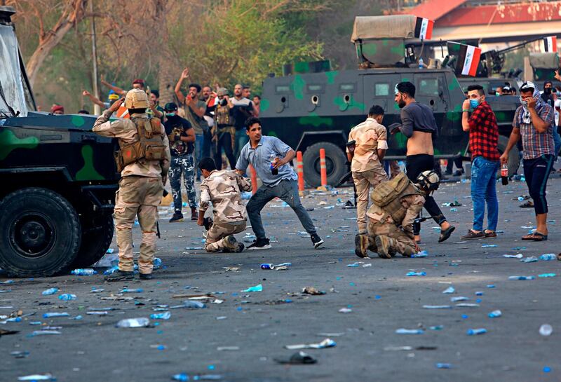 Security forces affected by tear gas are helped by several protesters during demonstrations in Basra. AP Photo