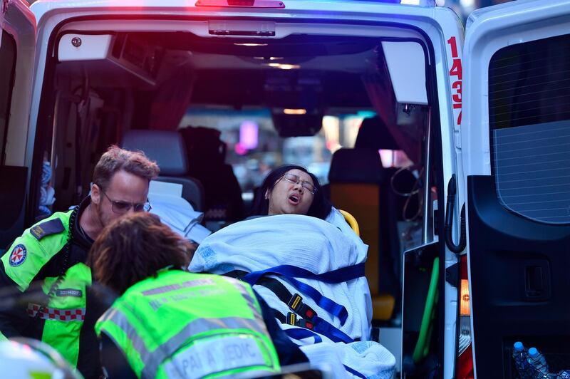 A women is taken by ambulance from Hotel CBD at the corner of King and York Street in Sydney, Australia.  AP