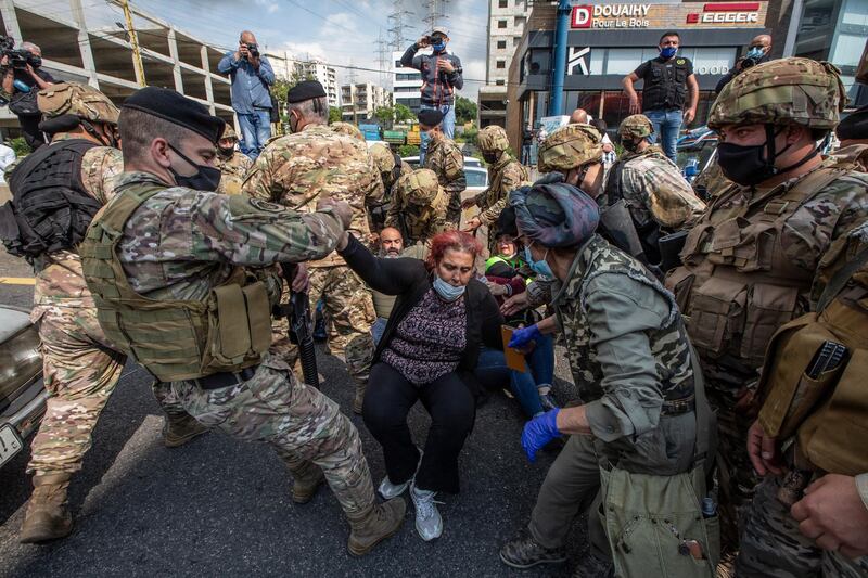 Lebanese army soldiers help supporters of Lebanese Christians parties  to open the Northern Highway during a protest against the collapsing Lebanese pound currency and the price hikes of goods, in Al-Zouk area, northern Beirut, Lebanon.  EPA