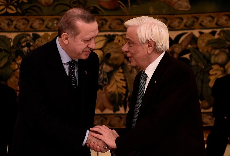 Turkish President Recep Tayyip Erdogan (L) shakes hands with Greece's President Prokopis Pavlopoulos at an official dinner in Athens on December 7, 2017, during a two day visit to Greece.  / AFP PHOTO / ANGELOS TZORTZINIS