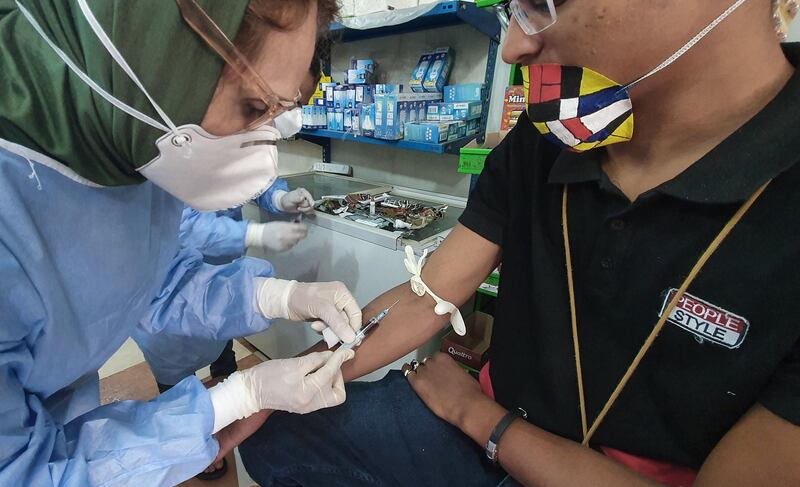 A Libyan doctor takes blood sample from a shopkeeper to test for the coronavirus in the Tajura area, a coastal suburb east of the capital Tripoli. AFP