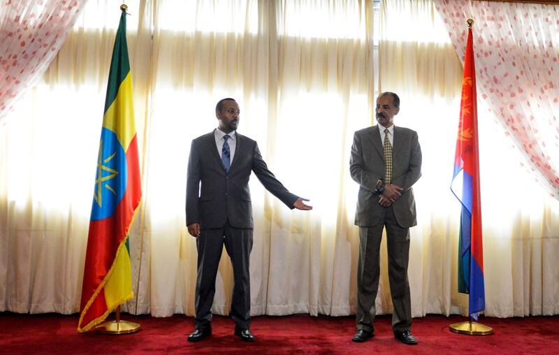 Ethiopian Prime Minister Abiy Ahmed (L) and President Isaias Afeworki of Eritrea (R) celebrate the opening of the Embassy of Eritrea in Ethiopia reopened following the official visit after twenty years, in Addis Ababa on July 13, 2018. / AFP / MICHAEL TEWELDE
