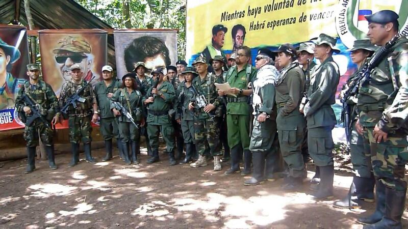 This TV grab taken from youtube and released on August 29, 2019 shows former senior commanders of the dissolved FARC rebel army group in Colombia, Ivan Marquez(C) and fugitive rebel colleague, Jesus Santrich(wearing sunglasses), on an undisclosed location announcing that they are taking up arms again along with other guerrillas who have distanced themselves from a peace accord signed with the government in 2016. Marquez, Marxist FARC's number two leader and chief negotiator of the 2016 peace agreement, had been unknown for more than a year. With UN support, the peace accord ended the insurrection by the Revolutionary Armed Forces of Colombia and turned it into a political party. 
 / AFP / YOUTUBE / -
