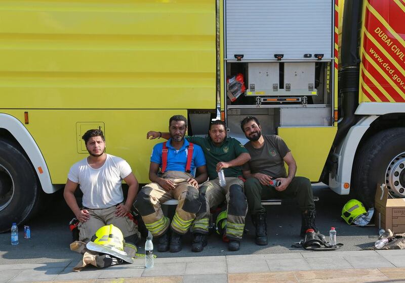 Abdulla Hassan, Sultan Ashor, Waleed Issa and Ashraf Khan from the Dubai Fire Station were amongst the first batch of firefighters to arrive on the scene last night. Here they rest after the fire was declared under controlon Friday afternoon. Victor Besa for The National.