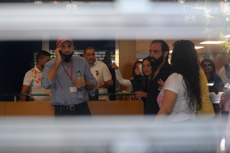 Lebanese depositors inside a Blom Bank branch in Beirut. A group of customers, at least one of whom was armed, took hostages in the bank, demanding access to their savings. They were reportedly able to withdraw $20,000 from an account of one of the depositors before they left.  EPA 