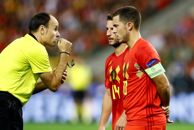 Referee Antonio Lahoz speaks with Belgium's Eden Hazard and Dries Mertens. Reuters