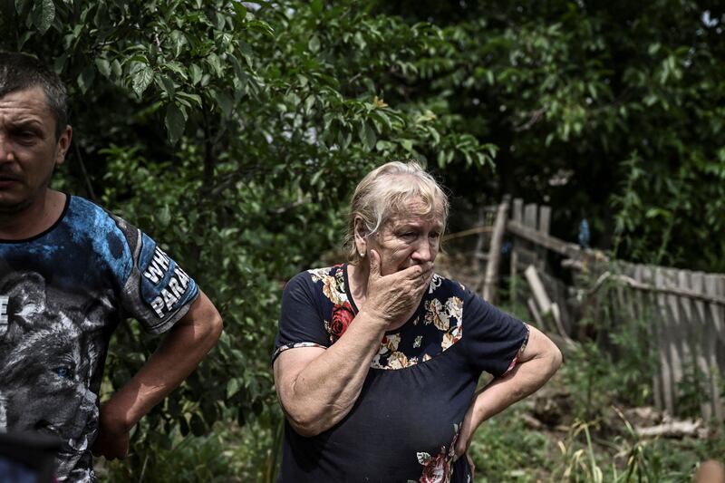 Lysychansk resident Yevgeniya Panicheva stands outside a house where two people were killed during shelling. The neighbouring city of Severodonetsk has been cut off from Lysychansk. AFP