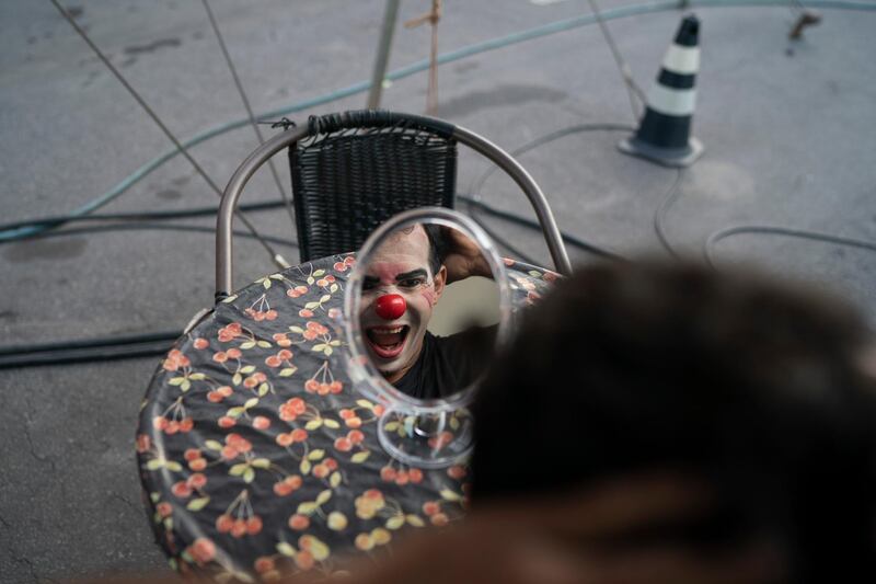 Anderson de Souza, the clown Batatinha, grimaces to the mirror as he puts on his clown face before performing at the Estoril Circus in Itaguai, greater Rio de Janeiro, Brazil. AP Photo