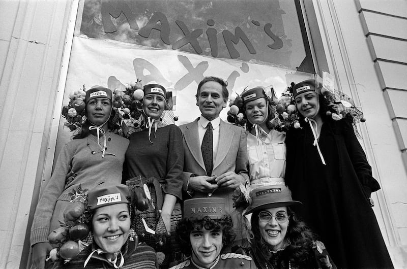 Pierre Cardin surrounded by 'Catherinette' in front of his new Parisian shop, Maxim's, in November 1977. AFP