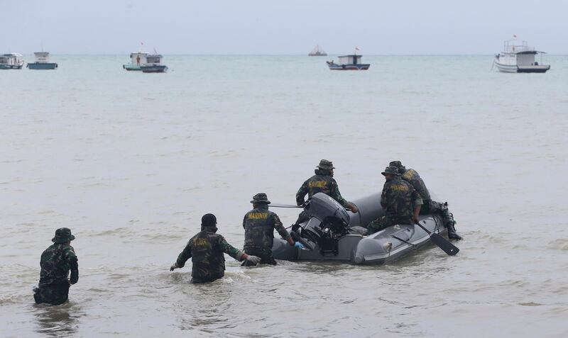 Marines search for victims at a beach in Sumur. AP Photo